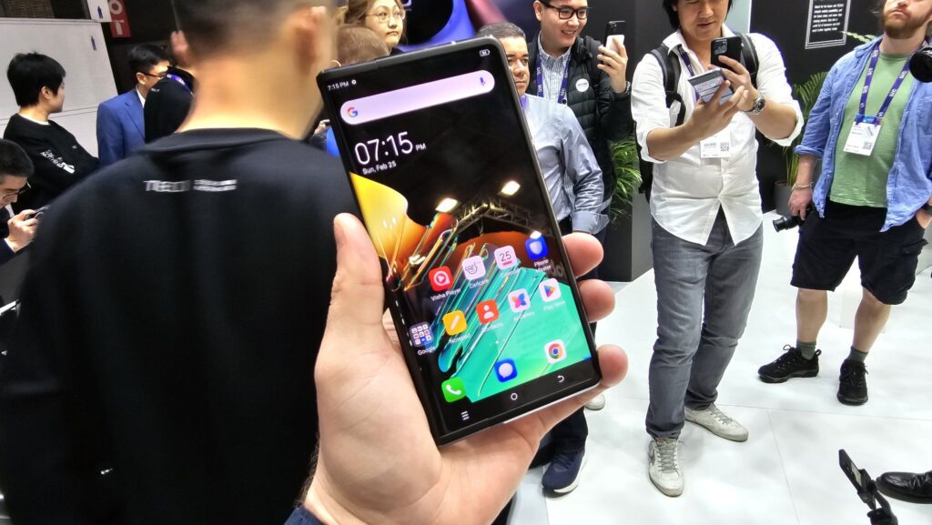 Tecno Phantom Ultimate: A rollable concept phone that unveils at MWC 2024. 1 Holding a rollable smartphone whic is the tecno phantom ultimate