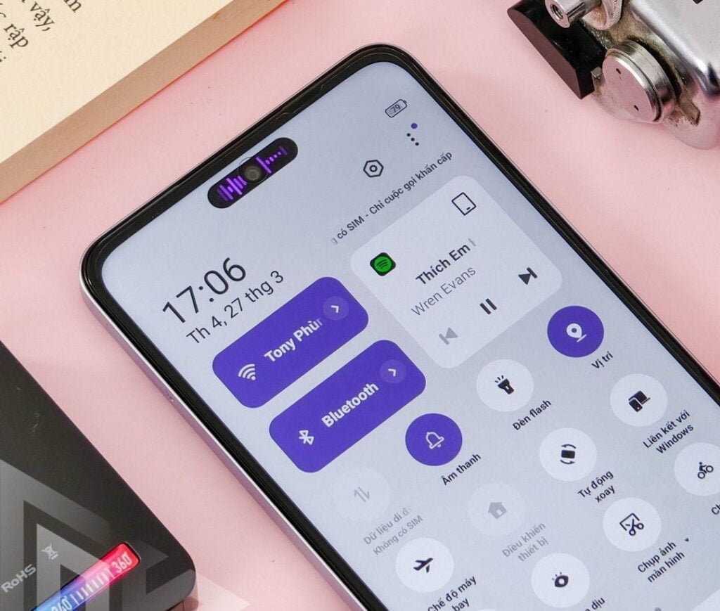 Realme C65 Teased Sleek Design and Near Launch 4 A Realme C65 smartphone displaying notifications and quick settings on the screen with a focus on bluetooth connectivity, placed on a pink surface next to some books.