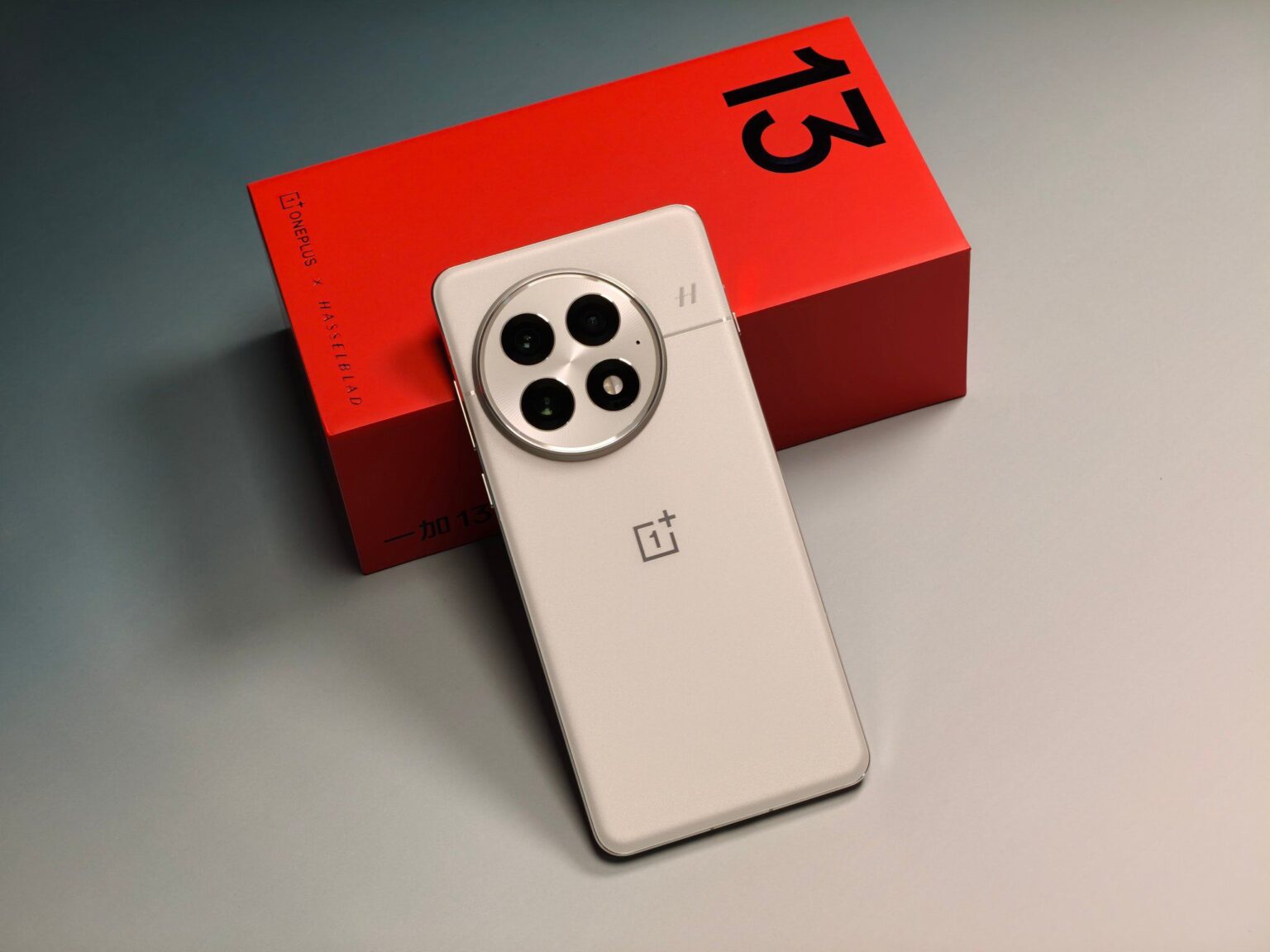 a smartphone iqoo 13 along-side the color red retail box and indicaging the number 13 in the box