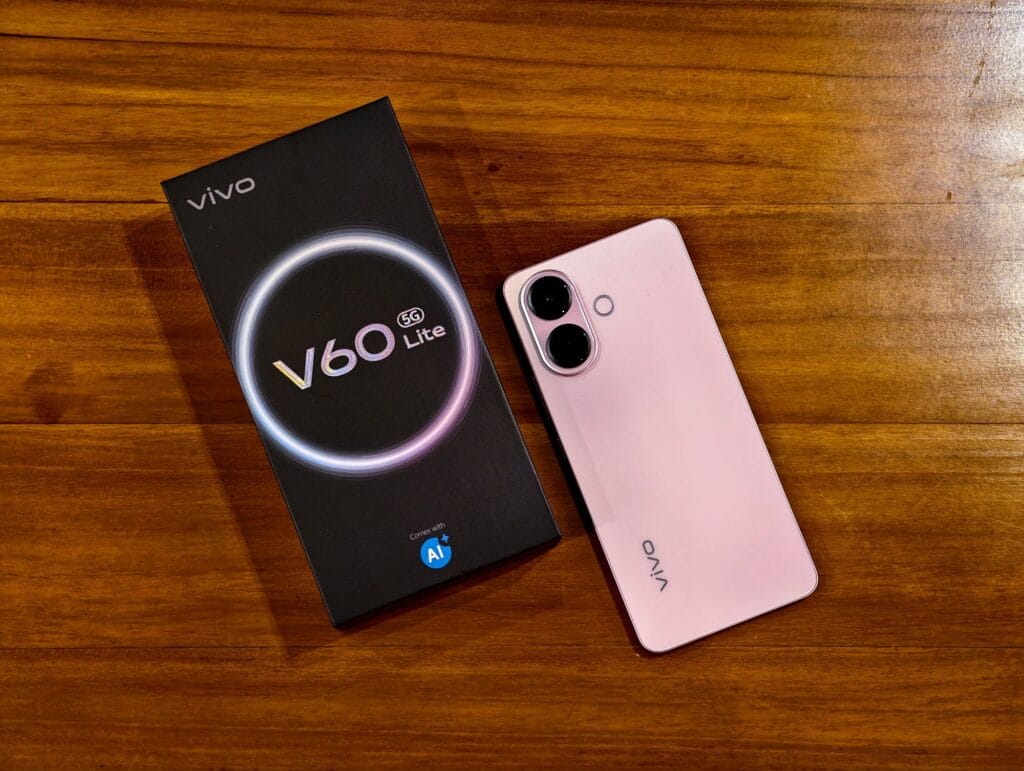 Vivo V60 Lite 5G | 6.77" FHD+ AMOLED, Dimensity 7360 Turbo, 50MP IMX882, and 6,500mAh Battery 1 Image of the Vivo V60 Lite 5G showcasing its sleek design and camera setup, next to its packaging.