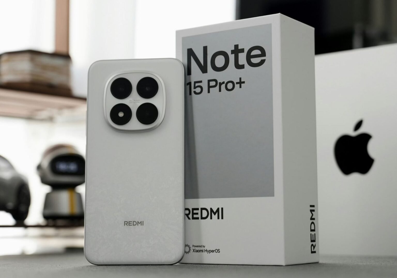 Redmi Note 15 Pro+ Spotted on Geekbench, Hinting at Global Launch Image of the Redmi Note 15 Pro+ beside its packaging, highlighting the phone's camera module and branding.