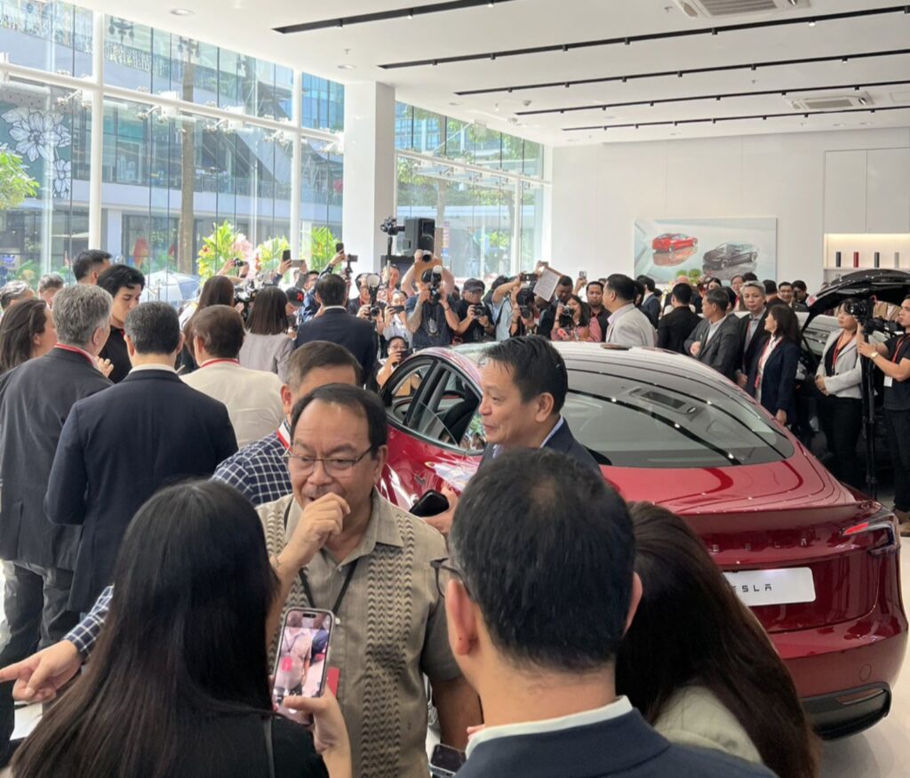 a peoples and reporters about launching of tesla model 3 electric sedan ev car in the philippines