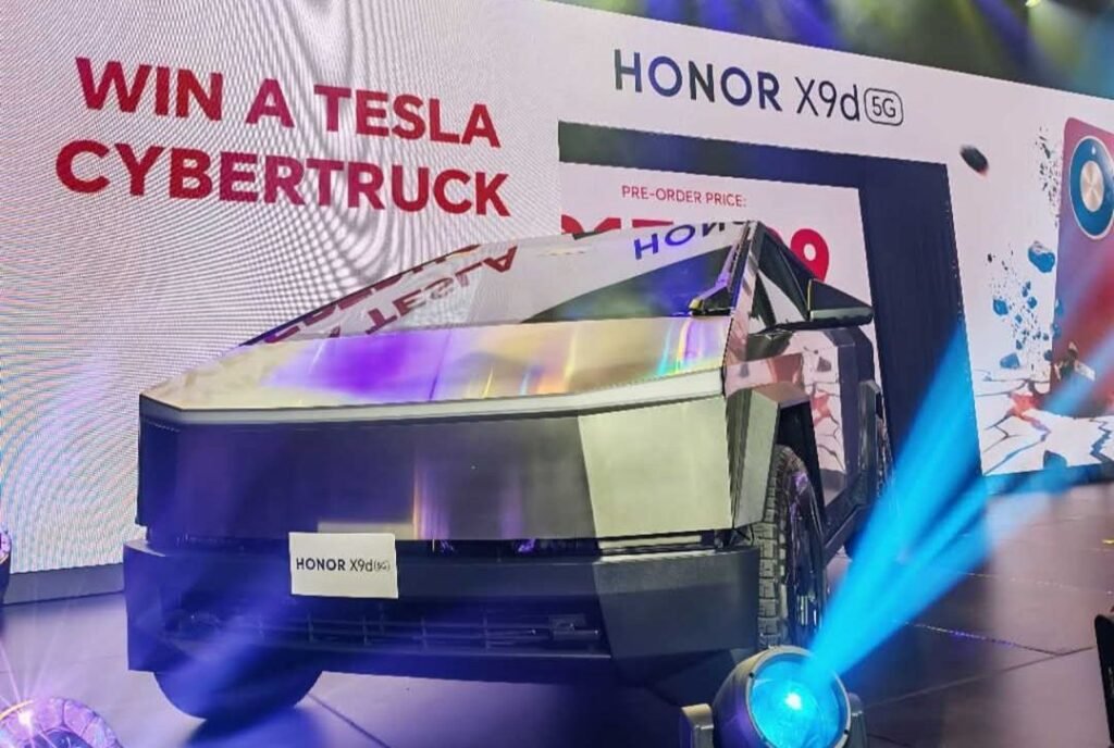 Tesla Cybertruck displayed on stage at the HONOR X9d 5G launch event in the Philippines. Large bold red text on the backdrop reads 'WIN A TESLA CYBERTRUCK', with 'HONOR X9d 5G' and partial 'PRE-ORDER PRICE' text visible nearby. A 'HONOR X9d 5G' label is attached to the front of the metallic, angular Cybertruck, and stage lighting (blue and purple beams) illuminates the scene. A graphic of the HONOR X9d phone variant is also partially shown on the backdrop.