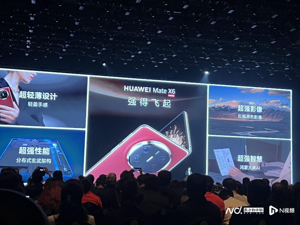 A Huawei Mate X6 launch event. Large screens display promotional material in Chinese and English.  The main image shows a red Huawei Mate X6 unfolding. Surrounding images highlight features using Chinese text: 超轻薄设计 (ultra-thin design), 超强性能 (super performance), 超强影像 (super imaging), and 超强智慧 (super intelligence). The audience is visible at the bottom of the image.