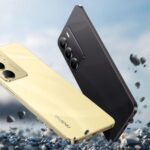 Two Realme C75 smartphones, one gold and one black, are shown falling amidst small rocks, emphasizing their rugged and durable design.