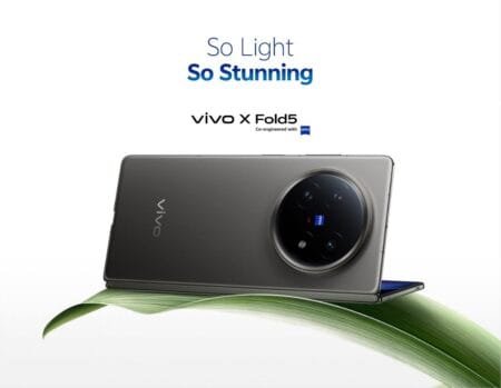 Vivo X Fold5 Officially Coming to the Philippines! A sleek, dark gray Vivo X Fold5 foldable phone is shown closed, subtly resting on a curved green leaf against a white background. The phone's circular camera module is prominent. The text "So Light So Stunning" is visible above.