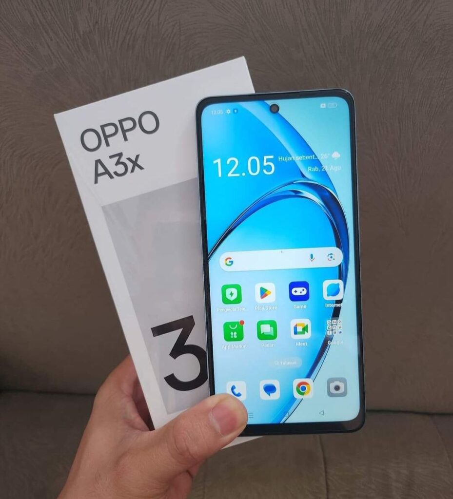 a person holding the oppo a3x features along-side of the box