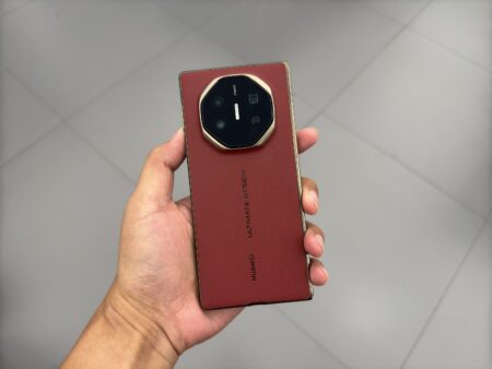 a person holding a smartphone huawei mate xt in color red variant