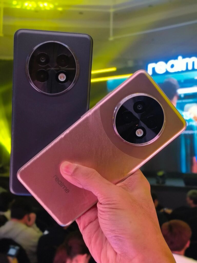 a person holding the two realme 13 5g features a dark purple and gloden red color variants