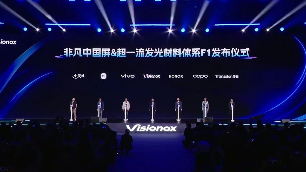 The Visionox F1 luminous material system launch event. Representatives from key Chinese smartphone brands are present on stage.