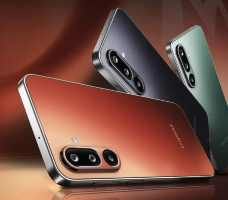Three Samsung Galaxy M36 5G smartphones showcasing their Orange Haze, Velvet Black, and Serene Green color options. The image highlights the phone's triple-lens camera system.