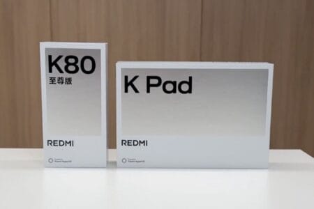 Two white product boxes on a table. The larger box displays 'Redmi K Pad' in black sans-serif font. The smaller box shows 'Redmi K80' and '至尊版' (meaning 'Supreme Edition' in Chinese) in black sans-serif font.