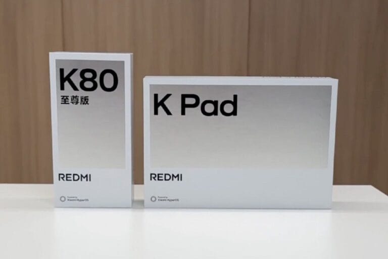Two white product boxes on a table. The larger box displays 'Redmi K Pad' in black sans-serif font. The smaller box shows 'Redmi K80' and '至尊版' (meaning 'Supreme Edition' in Chinese) in black sans-serif font.