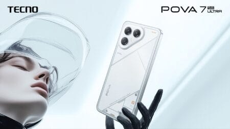 A close-up shot of the Tecno Pova 7 Ultra smartphone in white, held in a gloved hand. The phone's design features a distinctive camera module and geometric patterns. A person wearing a futuristic-looking transparent helmet is also in the background.