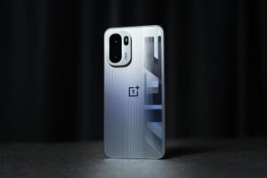 Silver OnePlus Ace 6 Turbo with a ridged back, showcasing its camera module, logo, and geometric design.