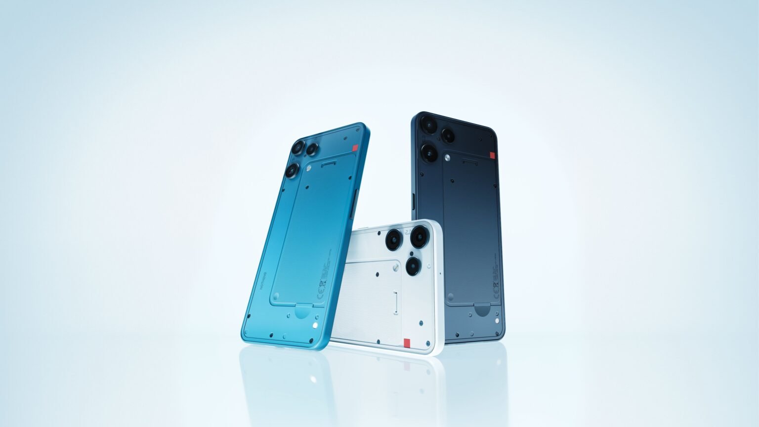 Close-up of three Nothing Phone (3a) Lite devices in blue, white, and black, showcasing their unique rear design.