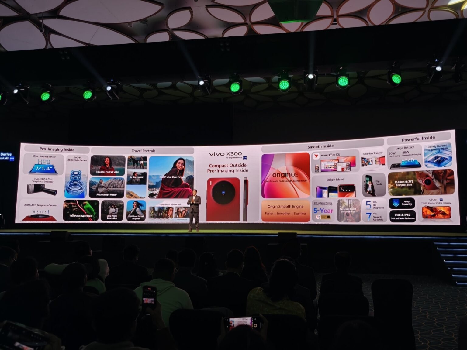 Vivo X300 Launched in India with Starting Price of ₹75,999 vivo X300 series launch event in India, with a presenter on stage and the phone's features displayed on a large screen.