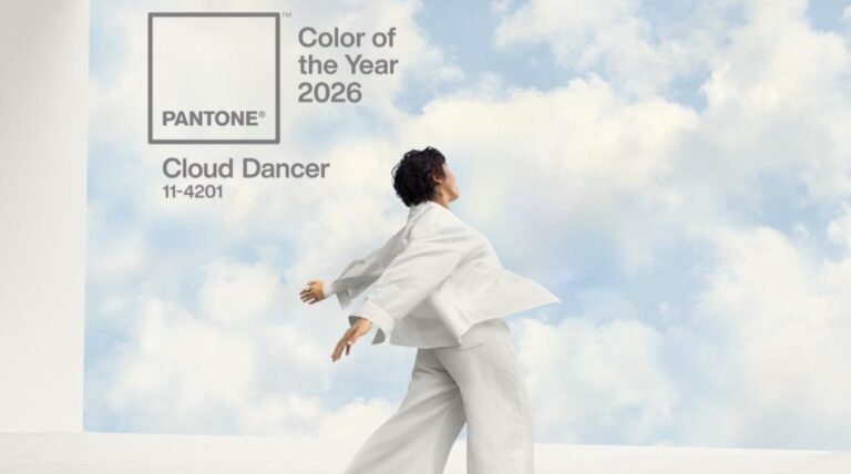 Pantone Color of the Year 2026 announcement featuring 'Cloud Dancer' (11-4201). A person in flowing white clothing stands against a backdrop of soft, cloud-filled sky, evoking tranquility.