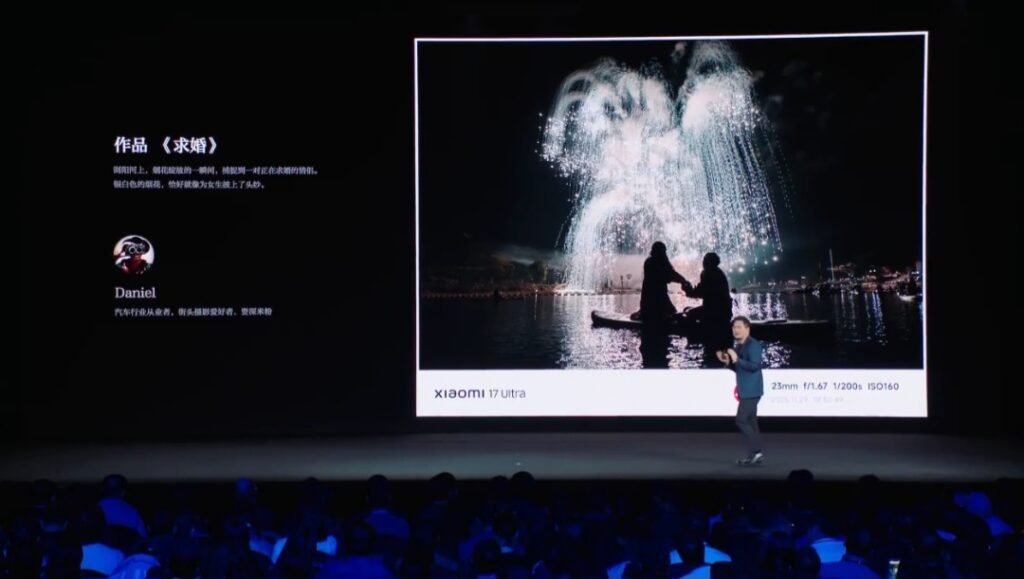 BREAKING: Xiaomi 17 Ultra Launches Today with Leica APO Telephoto, ‘Starry Green’ Design Xiaomi 17 Ultra launch event displaying a photo titled "Proposal": A silhouetted couple with fireworks, taken by photographer Daniel. Camera settings: 23mm, f/1.67, 1/200s, ISO160.