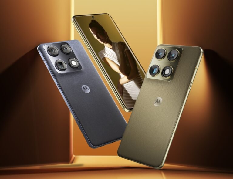 Three Motorola Signature smartphones floating against a warm golden background—two shown from the back in dark blue and gold finishes with quad-camera modules, and one facing forward displaying a portrait on the screen, highlighting the phone’s premium design and camera system.
