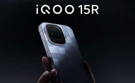 iQOO 15R Global Variant Appears on Geekbench: Snapdragon 8 Gen 5 Chipset Promotional image of the iQOO 15R smartphone. The device is held in a hand, showcasing its back with a textured checkered pattern and a large, rounded camera module with dual lenses. The model name 'iQOO 15R' is displayed in bold white text at the top against a dark background.
