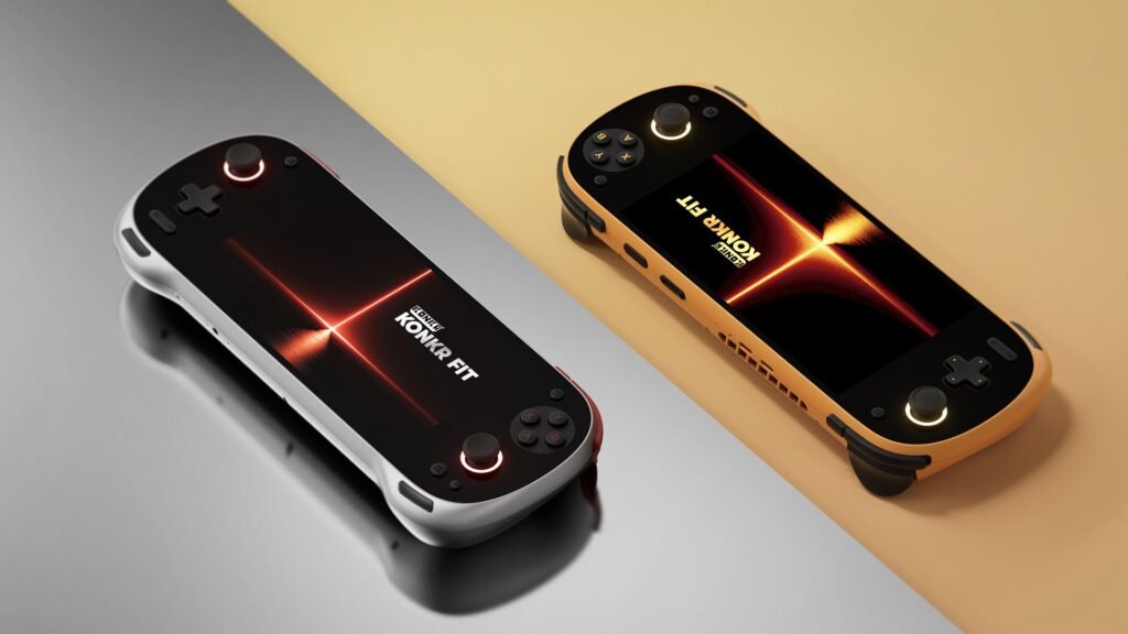 Two KONKR FIT handheld gaming consoles, one in Luminous Silver and one in Dragonveil Gold, resting on a split-tone reflective surface.