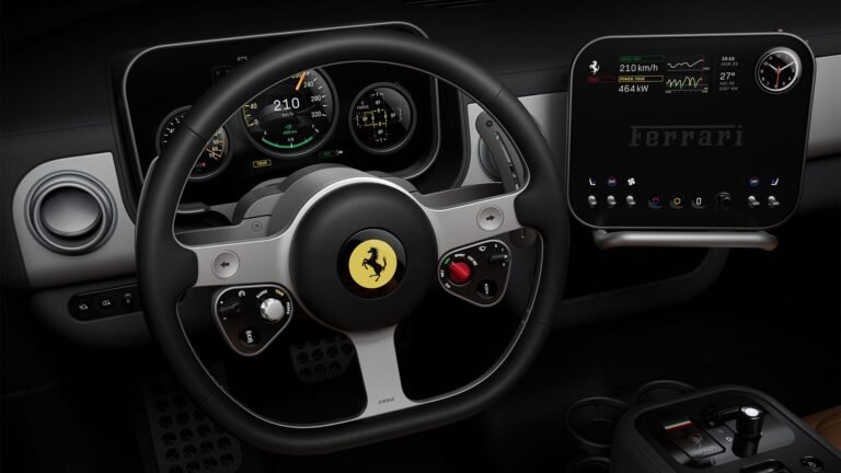 Ferrari Luce interior cockpit: Black leather-wrapped steering wheel with iconic prancing horse emblem, integrated controls, and red engine start button. Behind it, a multi-gauge digital instrument cluster displays speed (210 km/h), range, and vehicle data. To the right, a large central touchscreen shows performance metrics (464 kW power) and the Ferrari logo, with climate and connectivity controls below.