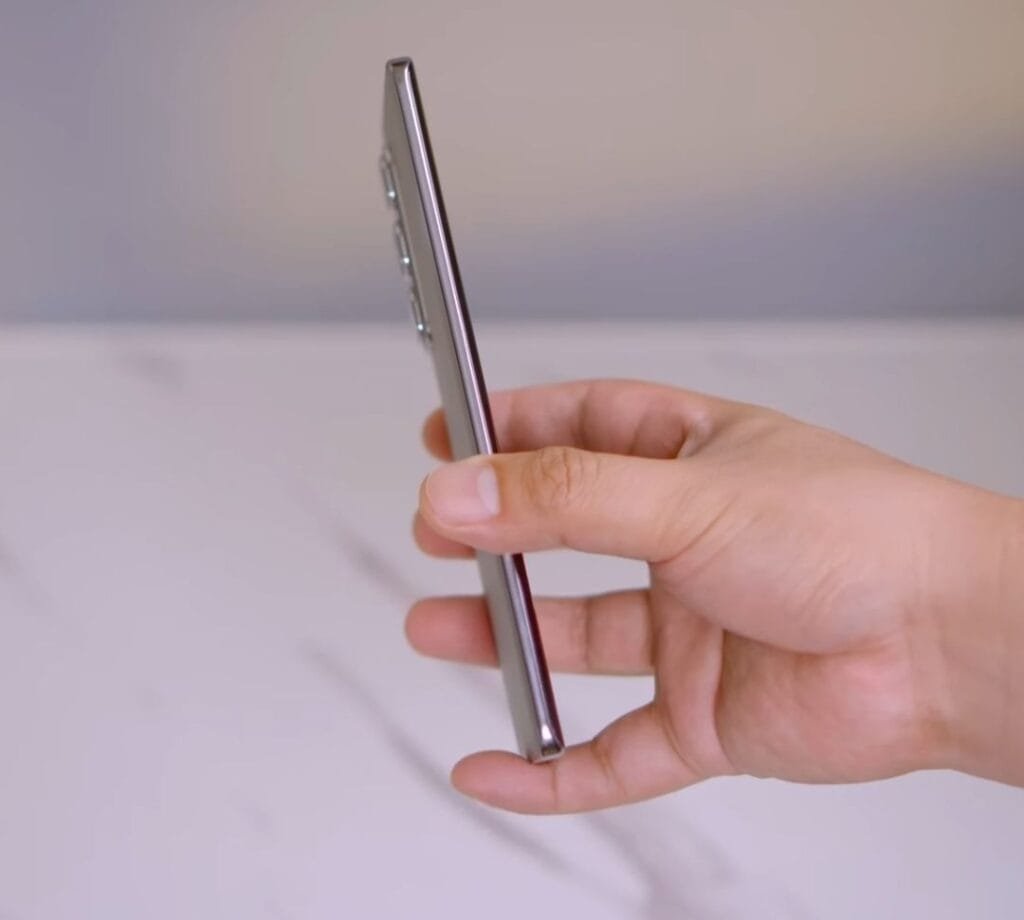 a person holding the infinix hot 50 pro+ 5g in side-view with 6.8mm thin