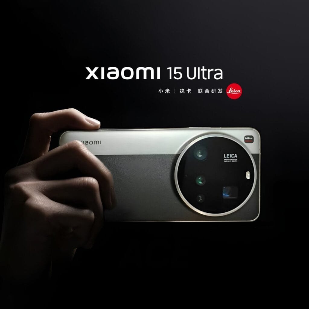 Xiaomi 15 Ultra Global Launch on March 2, 2025 A hand holds up a Xiaomi 15 Ultra smartphone, showcasing its large, circular Leica camera module. The phone is light gray or silver, and the background is black. The Xiaomi 15 Ultra branding is visible at the top.