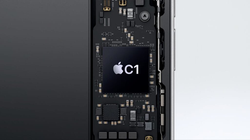 Close-up view of the Apple C1 chip, a 5G modem, integrated into the internal circuitry of an iPhone. The image shows the chip's location within the phone's motherboard, surrounded by other components.