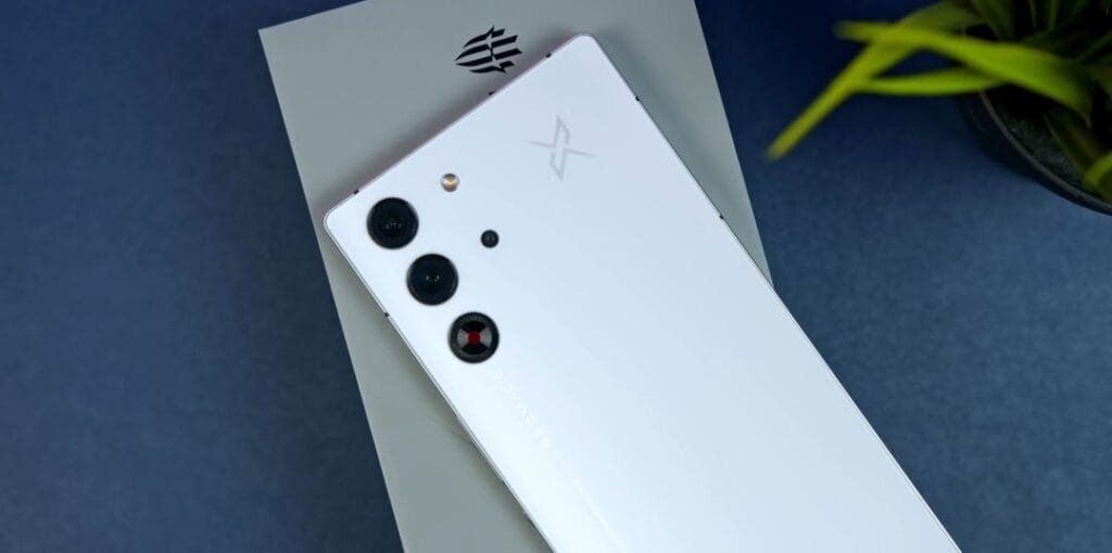 The RedMagic 10 Pro has officially arrived in the Philippines: Snapdragon 8 Elite, 7,050mAh battery. Price at ₱49,999 2 The back of a white RedMagic 10 Pro smartphone, showcasing its triple-lens camera system and subtle branding. The phone rests on its packaging.