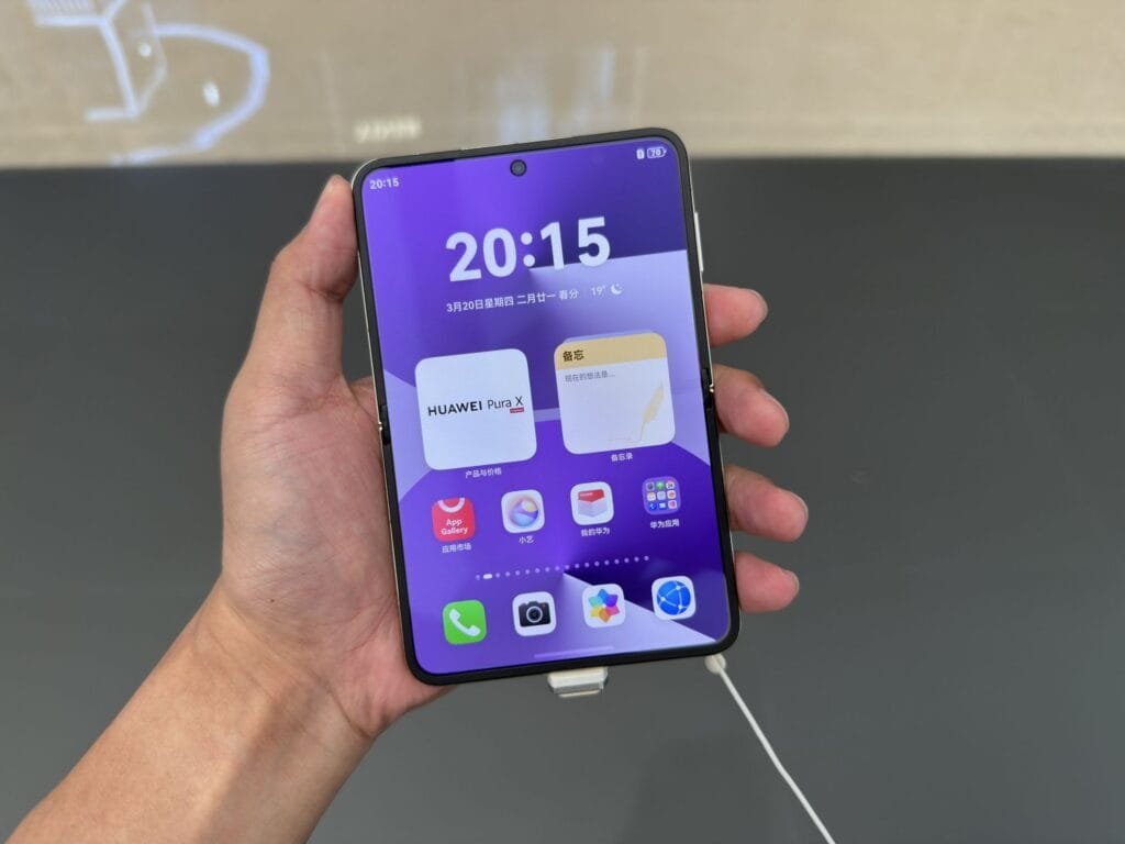 Huawei Pura X Clamshell Foldable Smartphone Launched in China 2 Close-up of a person's hand holding a white Huawei Pura X foldable phone, showing the home screen.