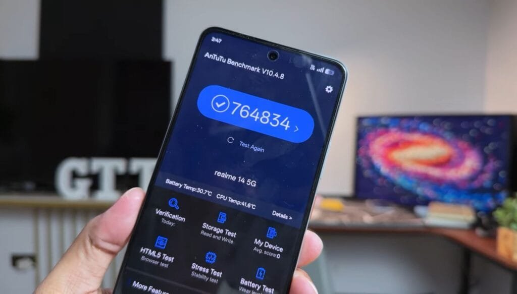 A Realme 14 5G phone displaying its AnTuTu benchmark score of 764834.