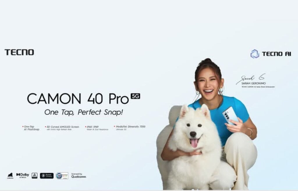‎A promotional image for the Tecno Camon 40 Pro 5G smartphone. Sarah Geronimo, the brand ambassador, smiles while holding the phone and cuddling a fluffy white Samoyed dog. The background is a light blue gradient. The phone's key features are listed at the bottom.