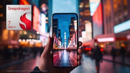 ‎A close-up shot of a person's hand holding a smartphone showcasing a stunning, brightly lit city street at night. The Snapdragon 7 Gen 4 logo is visible in the background, suggesting the phone's processor.