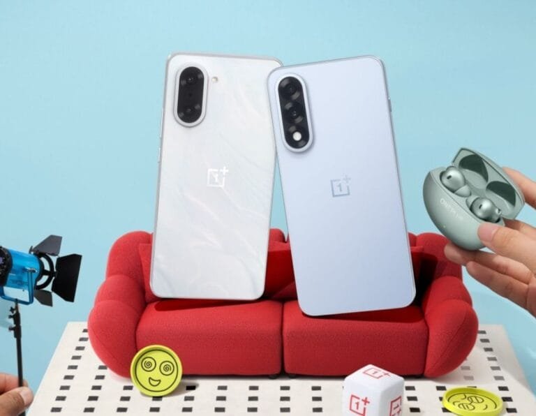 OnePlus Nord 5 | Flat OLED Display, 144Hz, and Snapdragon 8s Gen 3 Two OnePlus Nord 5 smartphones, one white and one light blue, are shown leaning against each other on a small red couch. A pair of OnePlus earbuds in a case rests nearby. The scene is playfully styled with miniature props.
