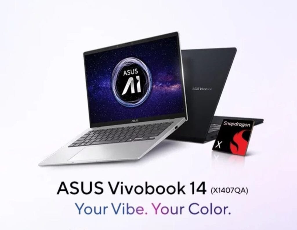 Asus Vivobook 14 Launched in India with Snapdragon X Processor A promotional image features the new Asus Vivobook 14 (X1407QA) laptop. A silver-colored laptop is prominently displayed, slightly angled, with its screen showing the Asus AI logo against a dark, starry background. A closed black Asus Vivobook laptop is partially visible behind it. A Snapdragon X processor chip is shown separately below. The tagline reads "Your Vibe. Your Color."