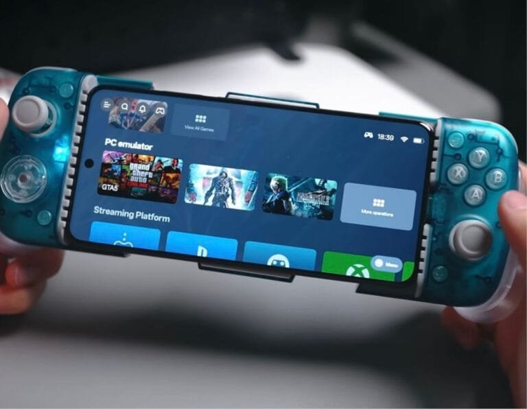 MediaTek Dimensity Chips Get a Boost for PC Game Emulation on Android Close-up of a person holding a smartphone in a teal GameSir controller. The phone screen shows a PC emulator interface with game titles like Grand Theft Auto V and others, indicating mobile PC game emulation.