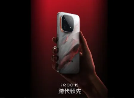 iQOO 15 to Debut with 2K LEAD OLED Display A hand holds the iQOO 15, showcasing its unique marble-like design and prominent camera module on a red background.