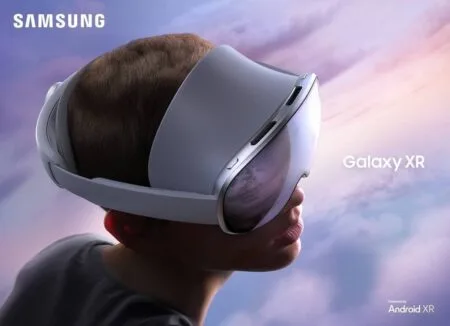 Samsung Galaxy XR Launched Globally A person wearing the Samsung Galaxy XR headset, seen from a low angle against a sky with clouds, showcasing the sleek, white design of the headset. The reflection in the visor hints at a virtual world, while the "Samsung" and "Galaxy XR" logos are prominently displayed. The bottom right corner indicates it's "Powered by Android XR."
