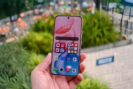 A hand holds an Honor smartphone with a pink and white gradient wallpaper. The screen displays the time as 17:03 and the date as Friday, July 11th. App icons for YouTube, Instagram, Telegram, and Google Play Store are visible.