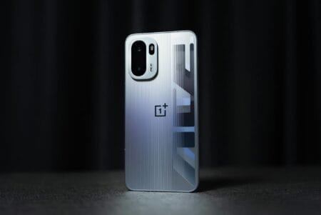 Silver OnePlus Ace 6 Turbo with a ridged back, showcasing its camera module, logo, and geometric design.