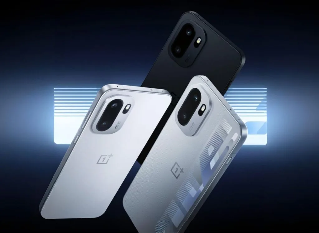 OnePlus Ace 6 Specifications Leaked Ahead of Official Launch 1 Close-up of three OnePlus Ace 6 phones in black, silver, and patterned silver finishes, arranged against a dark blue background with a bright neon light.