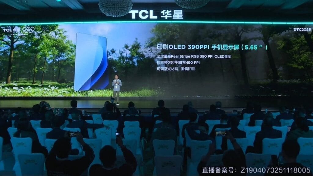 TCL Unveils Real Stripe RGB OLED Display with Enhanced Clarity and Efficiency 1 Audience members at a TCL event photograph a presenter on stage, who is discussing the new 5.65-inch Real Stripe RGB OLED display. The display's specifications are visible on a large screen.