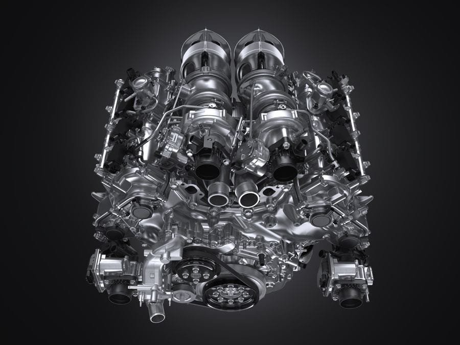 Toyota Gazoo Racing’s New GR GT3 Turns Heads as It Gears Up for Racetracks and Roads 2 A close-up, highly detailed image of a twin-turbo V8 engine, showcasing its polished metallic surface, twin turbochargers at the top, various pipes, and intricate components against a dark background.
