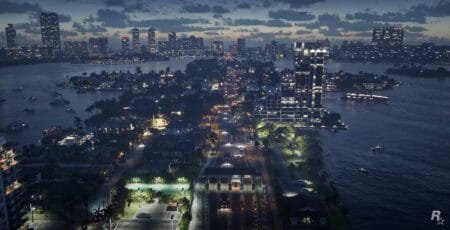 Dusk aerial view of a fictional tropical waterfront city (likely from Grand Theft Auto VI, indicated by the Rockstar Games logo), featuring a narrow island with a lit main road, residential homes, palm trees, a basketball court, and modern high-rises. Across the water, a dense city skyline glows under a cloudy twilight sky, with boats dotting the dark water.
