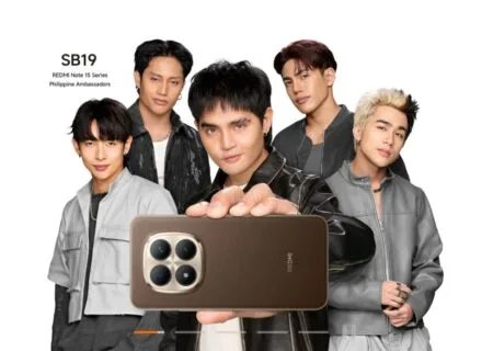 Filipino boy group SB19, named as Philippine Ambassadors for the Redmi Note 15 Series, pose together against a white background. One member holds up a brown Redmi Note 15 smartphone, displaying its quad-camera module with a metallic frame. Text in the top-left corner reads: 'SB19 – REDMI Note 15 Series Philippine Ambassadors'.