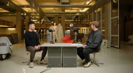 Carl Pei Outlines Nothing’s 2026 Strategy: No New Flagship, Phone (4a) Series Takes Priority Carl Pei (right, brown cap) in industrial-style studio, seated opposite guest at mic-equipped table, discussing Nothing’s 2026 strategy; design mannequin/decor in background.