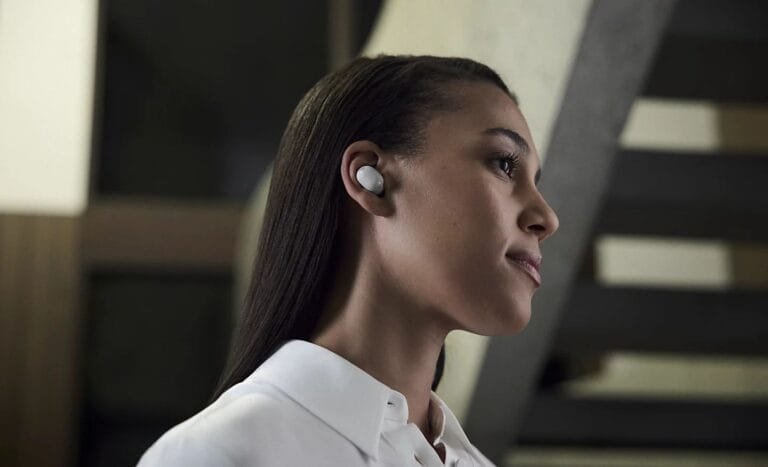 Sony Launches WF-1000XM6, WH-1000XM6 Worldwide Starting PHP 18,999 Side profile of a person wearing Sony WF-1000XM6 true wireless earbuds in white, highlighting the compact design in a modern indoor setting.