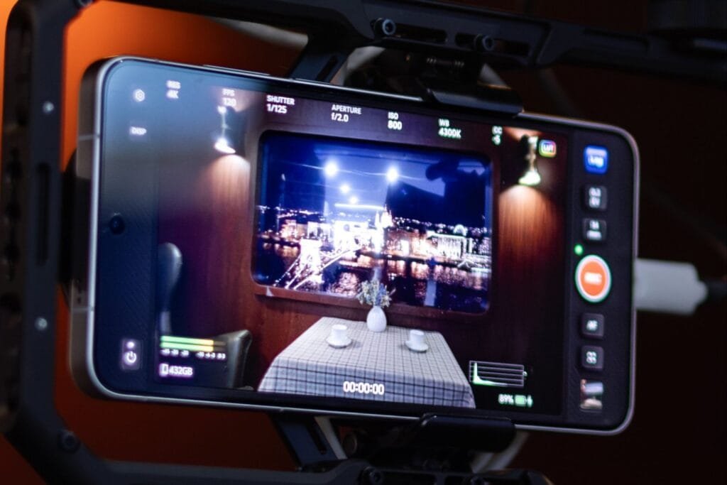 Vivo X300 Ultra Showcased at MWC 2026 with 400mm Teleconverter Kit 2 Vivo X300 Ultra mounted in a rig, displaying a professional video recording interface on its screen with settings like 4K resolution, 120fps, f/2.0 aperture, and a live view of an indoor scene with a cityscape visible through a window.